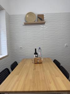 een houten tafel met twee flessen wijn en een tas bij Apartamento Central Rainha in Caldas da Rainha