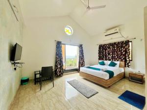 a bedroom with a bed and a tv and a window at Jk Valley Panchgani in Panchgani