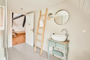 a bathroom with a sink and a mirror on the wall at Altes Fährhaus - Ferienwohnung Unnern, 170 qm in Wewelsfleth
