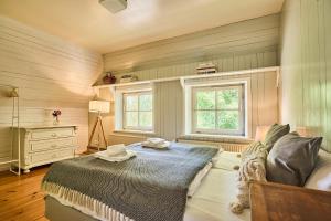 a bedroom with a bed and a dresser and two windows at Altes Fährhaus - Ferienwohnung Unnern, 170 qm in Wewelsfleth
