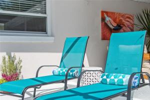Dos sillas azules sentadas en un patio en Madeira Beach Pool Home with Guest House, en San Petersburgo