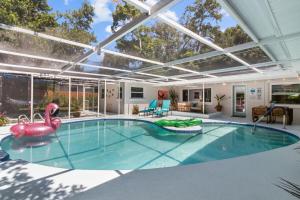 Una piscina cubierta con un flamenco inflable en una casa. en Madeira Beach Pool Home with Guest House, en San Petersburgo