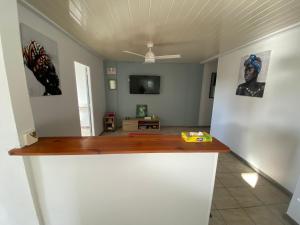 Una sala de estar con un mostrador y un televisor. en Résidence cannelle, en Les Trois-Îlets