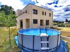 a house with a swimming pool in front of a house at L'appart du bonheur à Reims in Jonchery-sur-Vesle