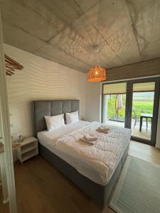 Un dormitorio con una cama grande con una ventana grande. en Domus Cobile, en Kobylí