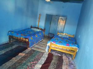 a bedroom with two beds and a blue wall at Arman House in Aswan