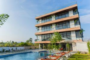 a building with a swimming pool in front of it at Sasa resort Udaipur in Udaipur