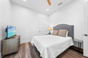 a bedroom with a bed and a flat screen tv at Luxury 4BR, Across street from beach, Sleeps 10! in Gulf Shores