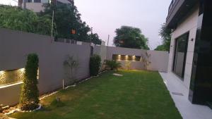 a backyard with a white fence and a yard with a yard at 3 bedroom modern house in Lahore