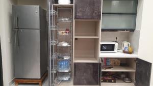 an empty kitchen with a refrigerator and a microwave at 3 bedroom modern house in Lahore