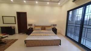 a bedroom with a large bed and a large window at 3 bedroom modern house in Lahore