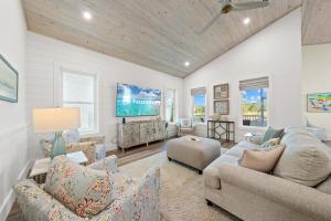 a living room with two couches and a flat screen tv at Luxury 4BR, Across street from beach, Sleeps 10! in Gulf Shores