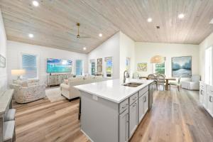 a kitchen and living room with white walls and wooden ceilings at Luxury 4BR, Across street from beach, Sleeps 10! in Gulf Shores