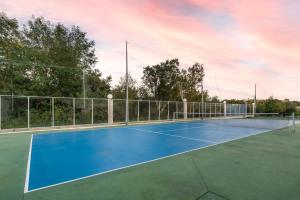 a tennis court with a blue tennis court at Calejo House – Pool & Sports & Grill Retreat in Nogueira
