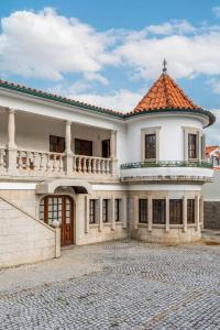 a large white building with a red roof at Calejo House – Pool & Sports & Grill Retreat in Nogueira