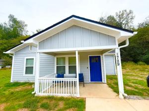 a small white house with a blue door at Bright, Cozy & Convenient - Minutes from UAB, Airport and Downtown Fun! in Birmingham