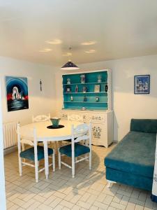 Una sala de estar con una mesa y sillas y un sofá. en Maison bleue proche de la mer, en Dar Salah Bey 10 fotos más