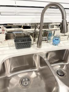 a kitchen sink with a dish basket on a shelf at Bright, Cozy & Convenient - Minutes from UAB, Airport and Downtown Fun! in Birmingham +51 photos