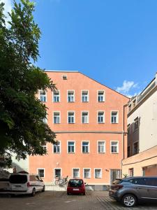 a large brick building with cars parked in a parking lot at Ferienwohnung NUMI direkt im Stadtzentrum Zittau kostenloser Parkplatz in Zittau +11 photos
