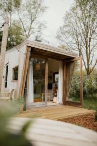 a tiny house with a large glass door at Tiny House Alba - ervaar tiny house living in Diessen
