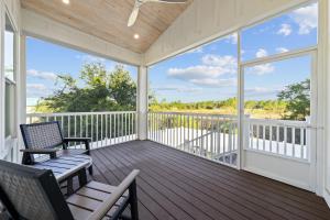 a screened porch with chairs and a view of the ocean at Luxury 4BR, Across street from beach, Sleeps 10! in Gulf Shores