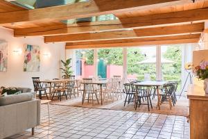 a dining room with tables and chairs and windows at Altes Fährhaus - Ferienwohnung Unnern, 170 qm in Wewelsfleth +47 photos
