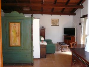 a living room with a green cabinet and a television at Le Case Del Vivaio in Sciacca