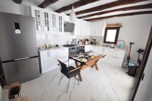 a kitchen with white cabinets and a table and a refrigerator at Villa Greta in Bodrum City