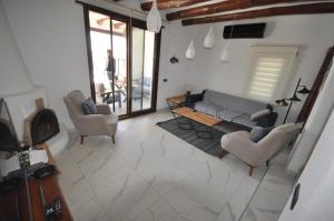 a living room with a couch and two chairs at Villa Greta in Bodrum City