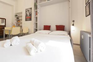 a bedroom with a large white bed with towels on it at PrimoPiano - Sempione in Milan