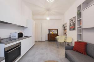 a kitchen and living room with a couch and a table at PrimoPiano - Sempione in Milan