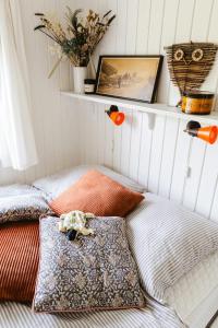Dos camas con almohadas en una habitación con un estante. en Romantic Island Cottage In Cosy Style Near Beach, en Maribo