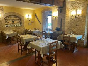 a restaurant with white tables and chairs and a wine cellar at Hotel Sovestro in San Gimignano