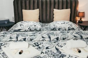 a bed with black and white sheets and pillows at CasaMaria in Slănic-Moldova