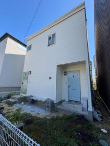 un gran edificio blanco con puerta y escaleras en StayChacha 城下町茶茶1F2F 一棟貸切, en Marugame