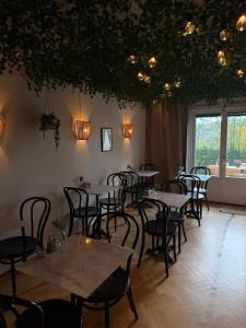 a restaurant with tables and chairs in a room at Ewa & Maude Hotel in Gothenburg