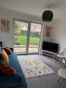 a living room with a blue couch and a tv at Spacious House Parking Pool Table in Balderton