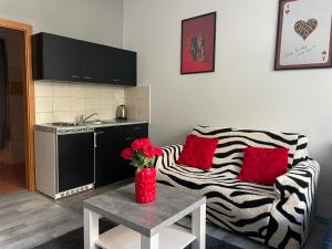 - un salon avec un canapé et une table avec des oreillers rouges dans l'établissement Tiffany Apartment in the City Center, à Bratislava