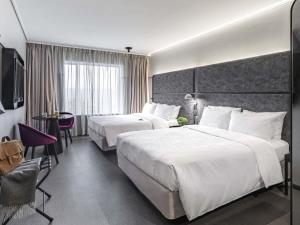a hotel room with two beds and a television at Pullman Santiago Vitacura in Santiago +169 photos