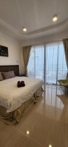 Un dormitorio con una cama grande y grandes ventanales. en Juara Mutiara Resort, en Tioman Island
