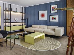a living room with a couch and a table at Pullman Santiago El Bosque in Santiago