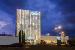 Un edificio alto con un cartel al costado. en Radisson Hotel Paris Le Bourget, en Le Bourget