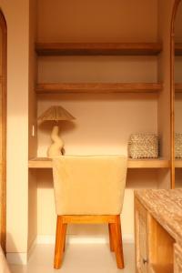 a chair sitting in a room with shelves at Pasir 5 - A stylish 2 bed villa in Bingin w pool in Bingin Beach