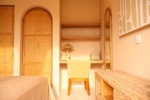 a bedroom with a chair and a table and shelves at Pasir 5 - A stylish 2 bed villa in Bingin w pool in Bingin Beach +16 photos
