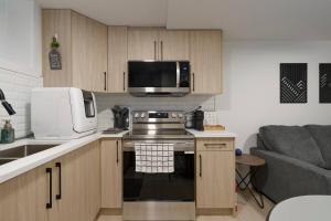 a small kitchen with a stove and a microwave at Modern Suite by Hospital 2 Near Transit, Wi-Fi, Netflix in Edmonton
