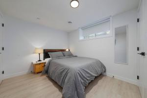 a white bedroom with a bed and a window at Modern Suite by Hospital 2 Near Transit, Wi-Fi, Netflix in Edmonton