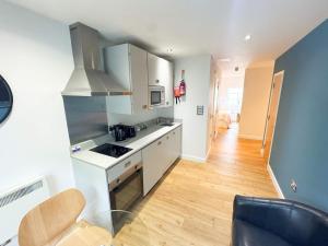 a kitchen with white cabinets and a wooden floor at Harford House Studios 21 - Hopewell in Bristol