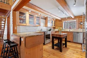 a kitchen with wooden cabinets and a wooden table at RMR: Teton View Cabin Home in WilsonWY in Wilson