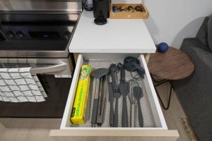 a drawer filled with kitchen utensils next to a stove at Modern Suite by Hospital 2 Near Transit, Wi-Fi, Netflix in Edmonton +13 photos