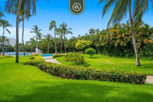 a park with palm trees and a pathway at Stylish 2 BR Condo - Pools - Golf - Membership in Jarretadera